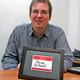 Carlson with a framed replica of his popular 2002 name-tag design.